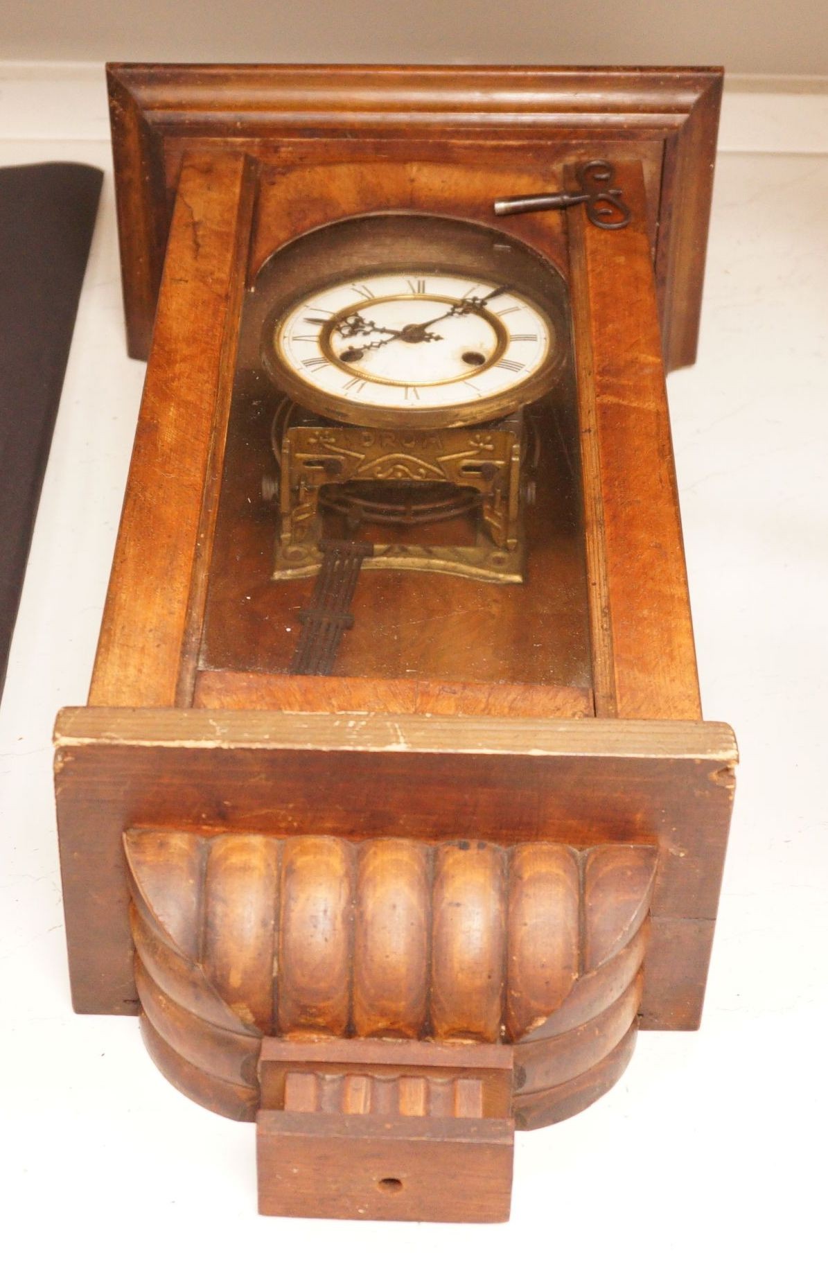 A small German wall clock with key, 58cm